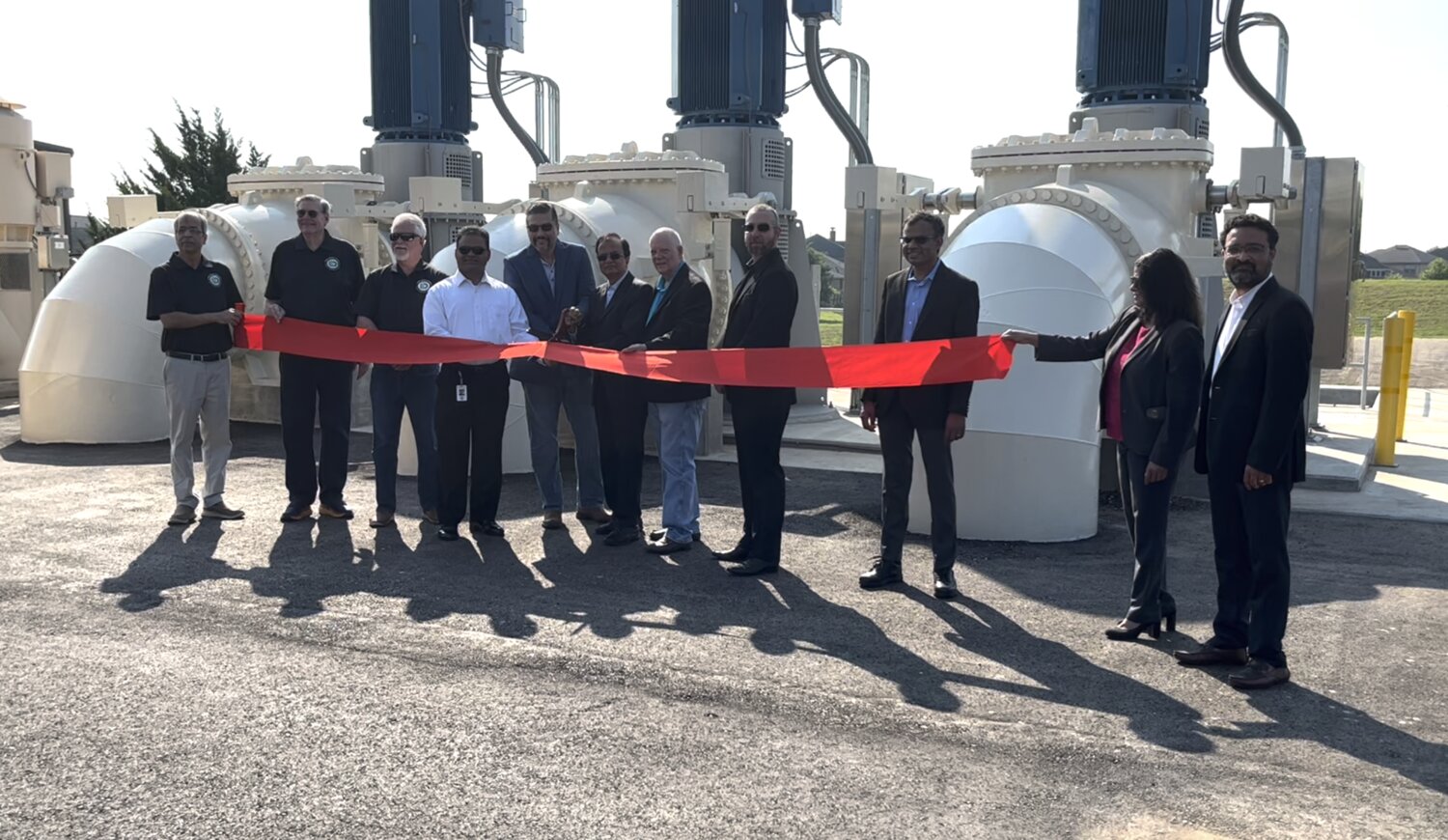 Officials, including Fort Bend County Judge KP George, fourth from left, and Pct. 3 Commissioner Andy Meyers, seventh from left, perform the ceremonial ribbon cutting at the Steep Bank Creek Pump Station.